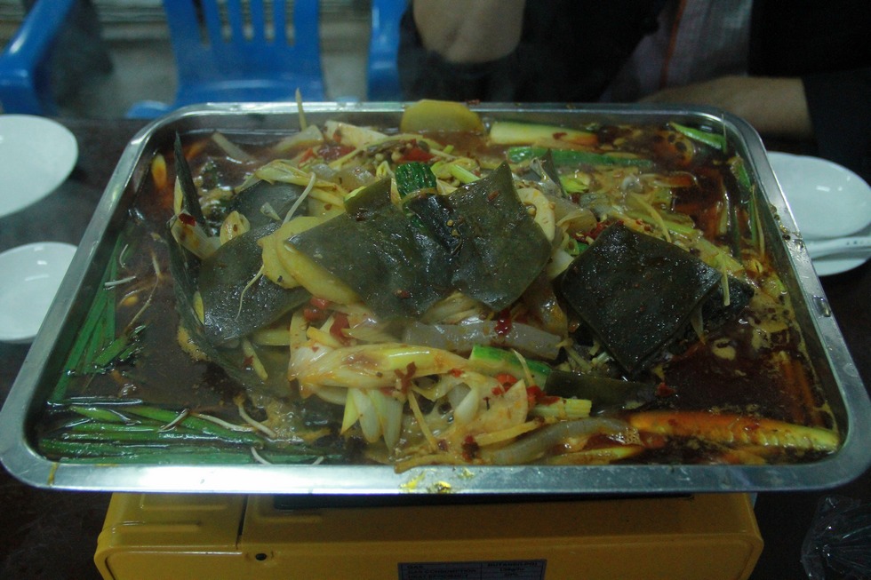 顾客品尝范正荣烹饪的烤鱼（周宗贵 摄） (2).jpg